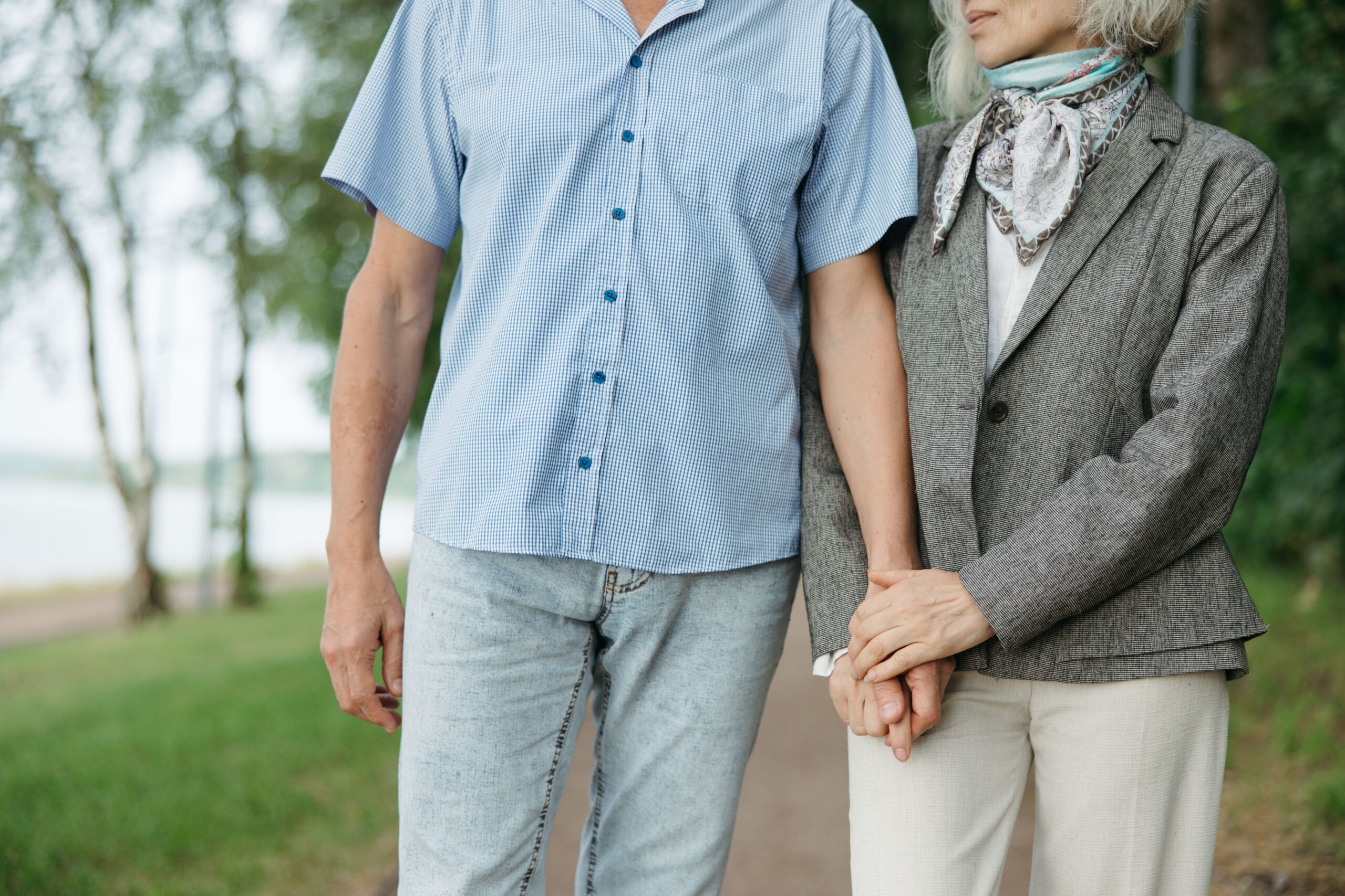 Older couple holding hands on a park path
