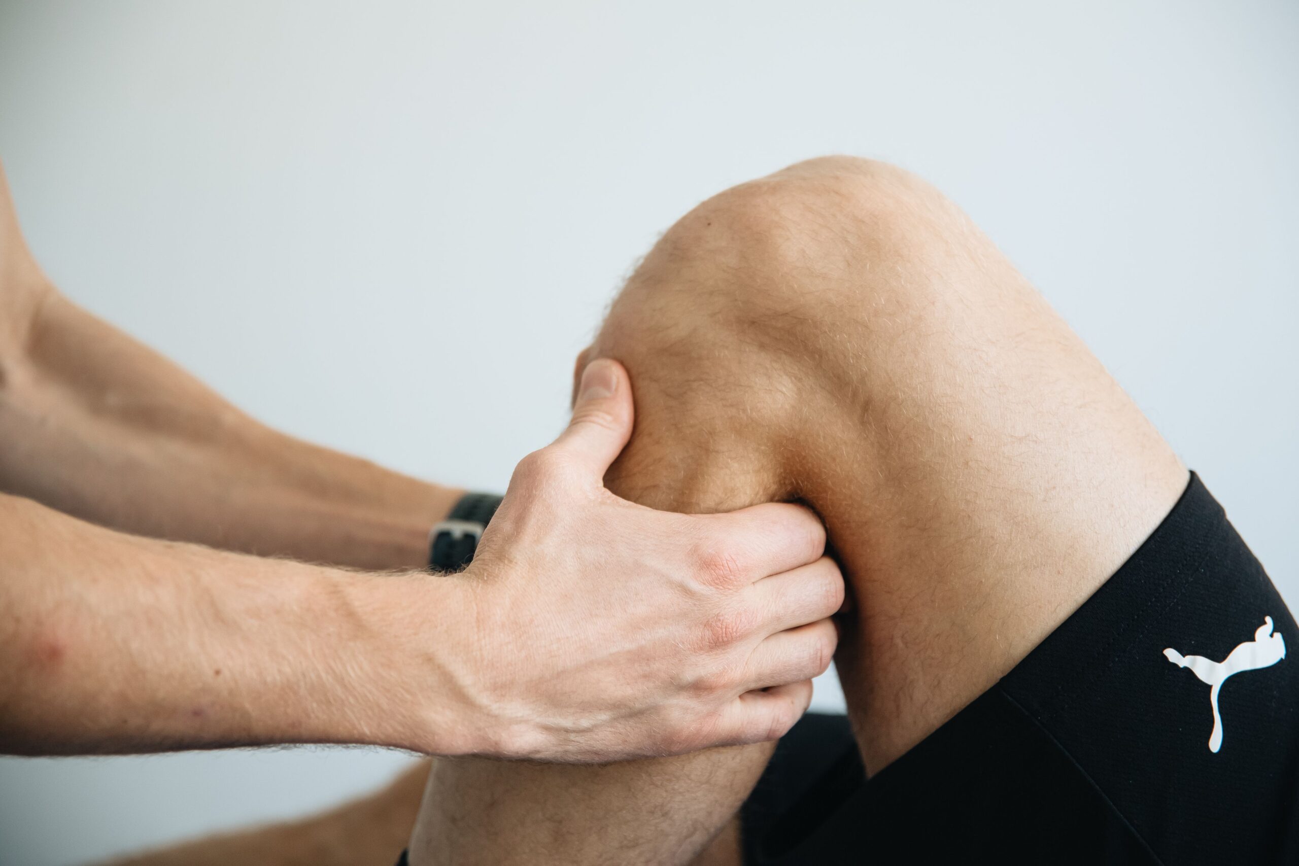 Physiotherapist supporting a bent knee during treatment